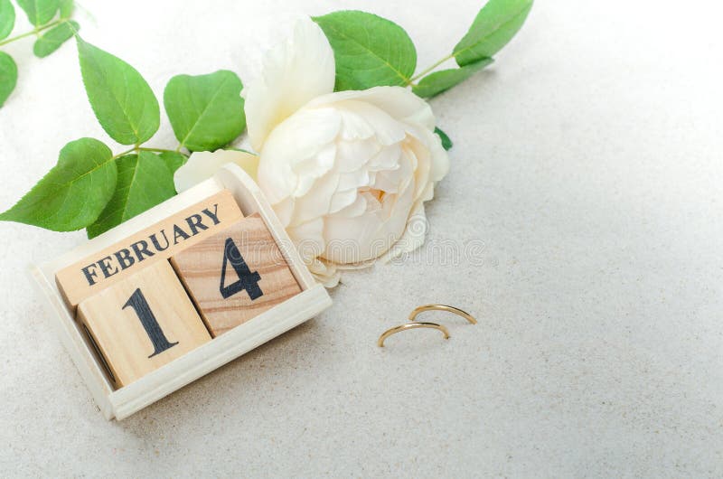 Februari 14, träkalender med cirklar och blomma på sandbackg royaltyfria bilder Februari 14, träkalender med cirklar och blomma på sandbackg royaltyfria bilder