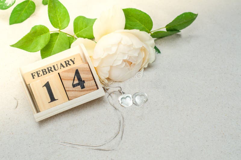 Februari 14, träkalender med hjärtaformmedaljongen och blomma royaltyfria foton Februari 14, träkalender med hjärtaformmedaljongen och blomma royaltyfria foton