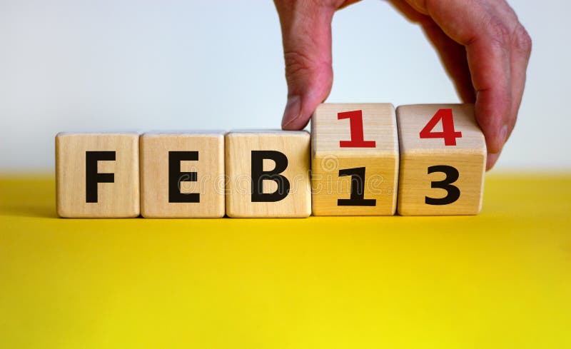 February 14 valentines day symbol. Hand turns cubes and changes the word `Feb 13` to `Feb 14`. Beautiful yellow table, white background, copy space. February 14 Valentines day concept. February 14 valentines day symbol. Hand turns cubes and changes the word `Feb 13` to `Feb 14`. Beautiful yellow table, white background, copy space. February 14 Valentines day concept.