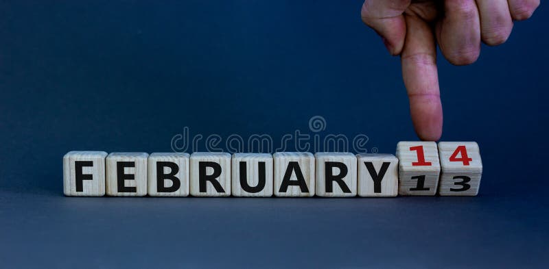 February 14 valentines day symbol. Hand turns cubes and changes the word 'February 13' to 'February 14'. Beautiful grey background  copy space. February 14 Valentines day concept. February 14 valentines day symbol. Hand turns cubes and changes the word 'February 13' to 'February 14'. Beautiful grey background  copy space. February 14 Valentines day concept