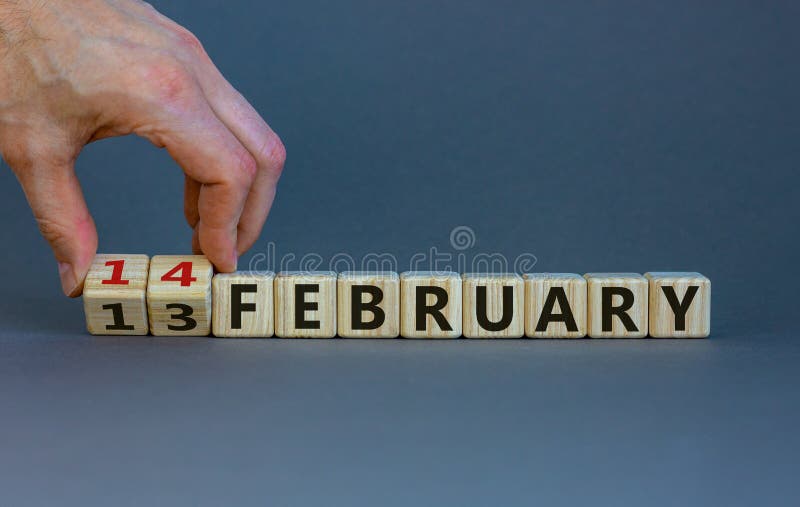 February 14 valentines day symbol. Hand turns cubes and changes the word 'February 13' to 'February 14'. Beautiful grey background  copy space. February 14 Valentines day concept. February 14 valentines day symbol. Hand turns cubes and changes the word 'February 13' to 'February 14'. Beautiful grey background  copy space. February 14 Valentines day concept