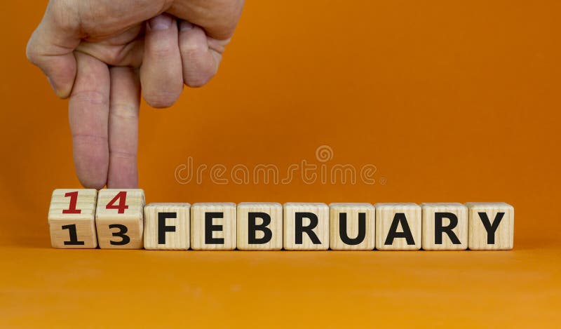 February 14 valentines day symbol. Hand turns cubes and changes the word 'February 13' to 'February 14'. Beautiful orange background  copy space. February 14 Valentines day concept. February 14 valentines day symbol. Hand turns cubes and changes the word 'February 13' to 'February 14'. Beautiful orange background  copy space. February 14 Valentines day concept