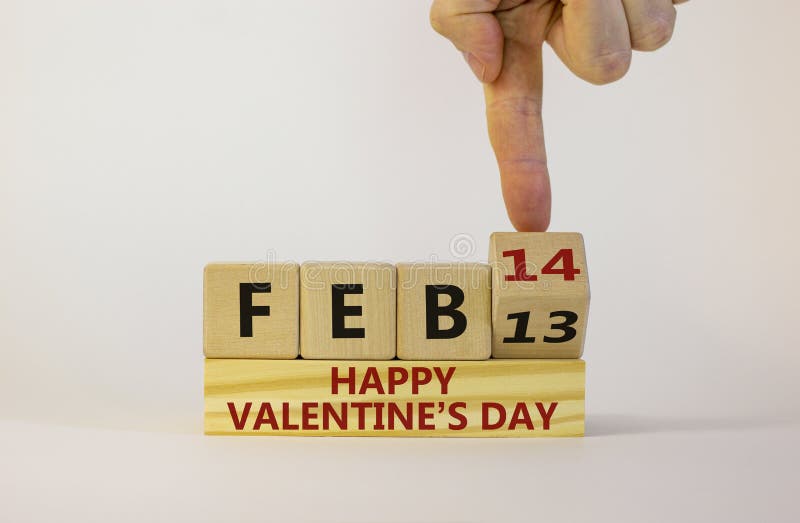 February 14 valentines day symbol. Hand turns a wooden cube. Words 'Feb 14 happy valentines day'. Beautiful white background  copy space. February 14 valentines day concept. February 14 valentines day symbol. Hand turns a wooden cube. Words 'Feb 14 happy valentines day'. Beautiful white background  copy space. February 14 valentines day concept