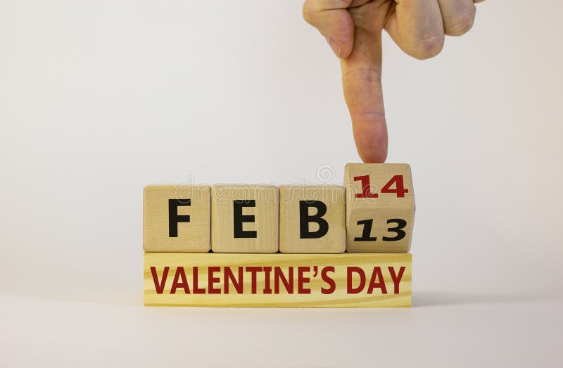 February 14 valentines day symbol. Hand turns a wooden cube. Words `Feb 14 valentines day`. Beautiful white background, copy space. February 14 valentines day concept. February 14 valentines day symbol. Hand turns a wooden cube. Words `Feb 14 valentines day`. Beautiful white background, copy space. February 14 valentines day concept.