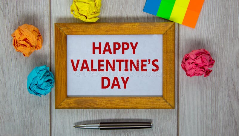 14 februari valentijnsymbool. houten frame met woorden happy valentines day. pen gekleurd papier. prachtige houten ruggengraat
