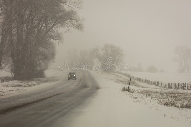 FEBRUARY 24, 2019 - RIDGWAY COLORADO USA - Winter snowy road through deep snow leads to San Juan Mountains leaving tire tread trai stock photo FEBRUARY 24, 2019 - RIDGWAY COLORADO USA - Winter snowy road through deep snow leads to San Juan Mountains leaving tire tread trai stock photo