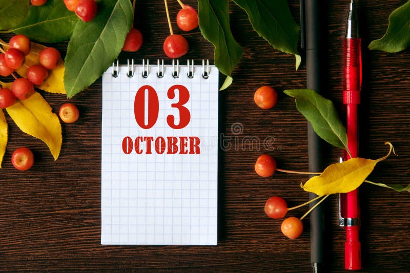 calendar date on wooden dark desktop background with autumn leaves and small apples. October 3 is the third day of the month. calendar date on wooden dark desktop background with autumn leaves and small apples. October 3 is the third day of the month.