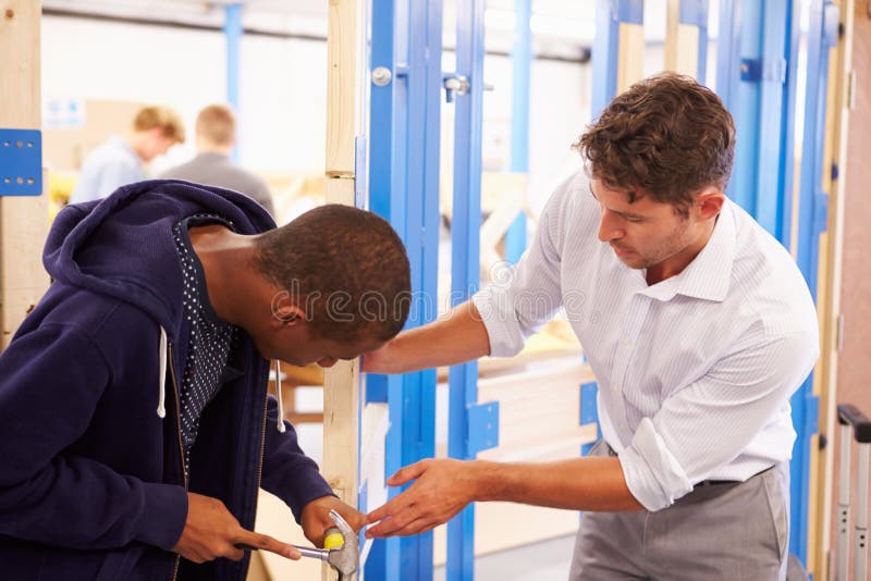 Fechadura da porta apropriada da classe da carpintaria de With Student In do professor imagem de stock Fechadura da porta apropriada da classe da carpintaria de With Student In do professor imagem de stock
