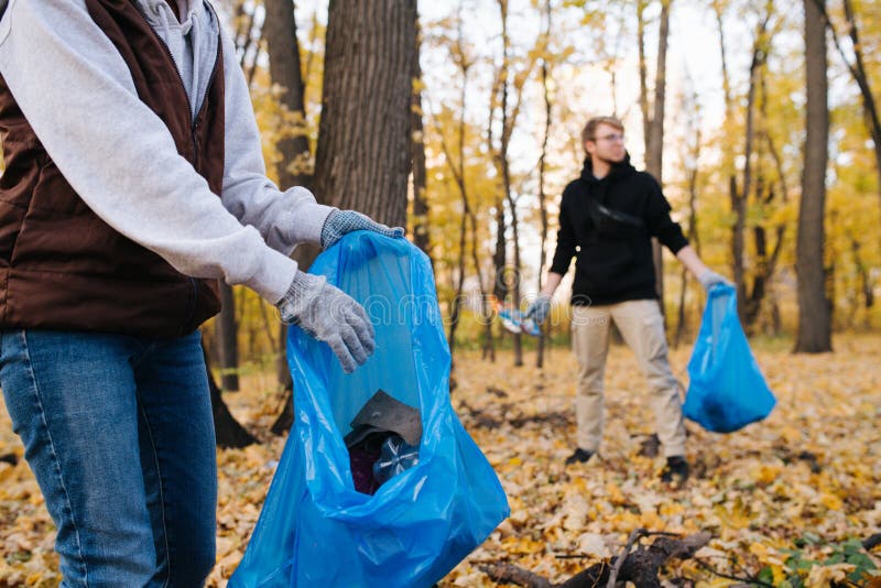 Fechamento de um grupo de voluntários coletando lixo na floresta sazonal no outono