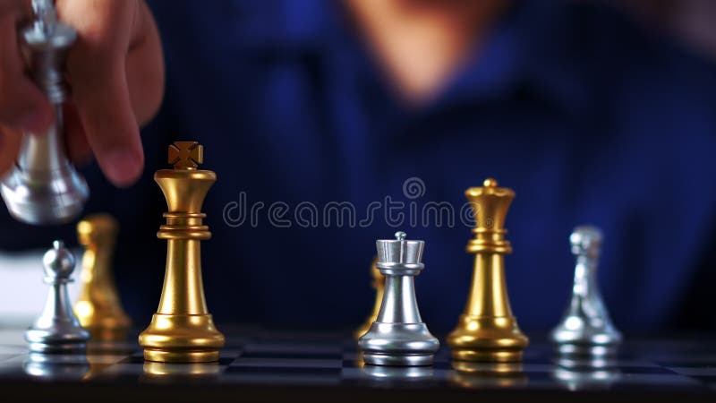 mão do empresário segurando o xadrez rei dourado para lutar contra