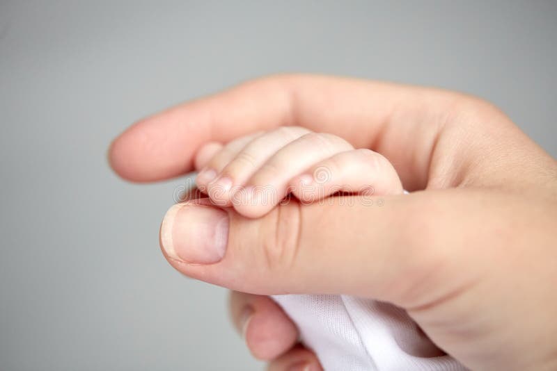 Feche acima da mãe e das mãos recém-nascidas do bebê fotografia de stock Feche acima da mãe e das mãos recém-nascidas do bebê fotografia de stock