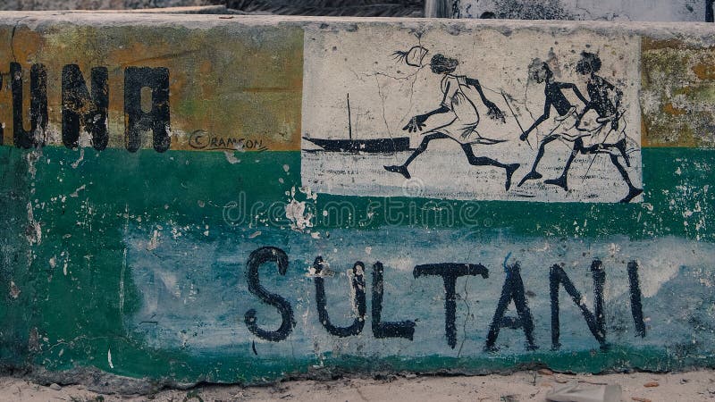 Close up of street sign in Jambiani, Zanzibar. The sign has a detailed painting of three fisherman and a dhow. Background is yellow and green, with streetname: Sultani. Close up of street sign in Jambiani, Zanzibar. The sign has a detailed painting of three fisherman and a dhow. Background is yellow and green, with streetname: Sultani