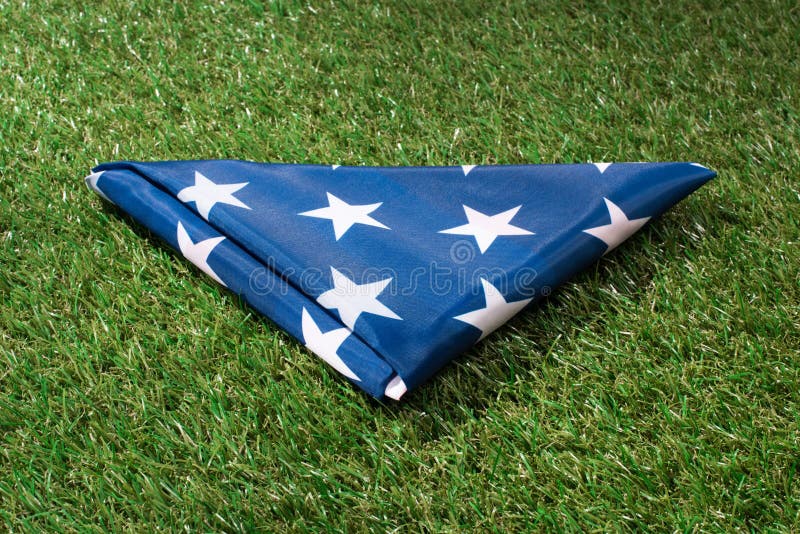 feche acima da vista da bandeira americana dobrada no gramado verde, independência de americas