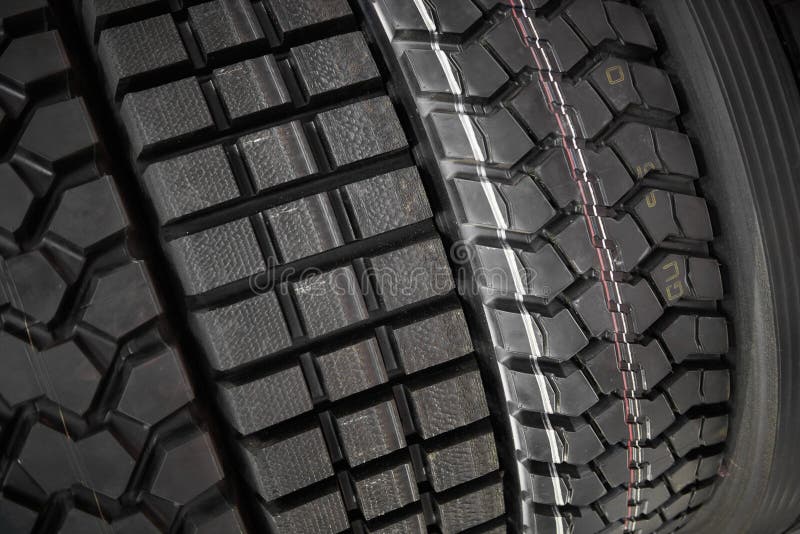 Feche acima da vista em caminhões pesados e os pneus novos da roda dos tratores surgem Teste padrão e tipo diferentes pneus para fotografia de stock Feche acima da vista em caminhões pesados e os pneus novos da roda dos tratores surgem Teste padrão e tipo diferentes pneus para fotografia de stock