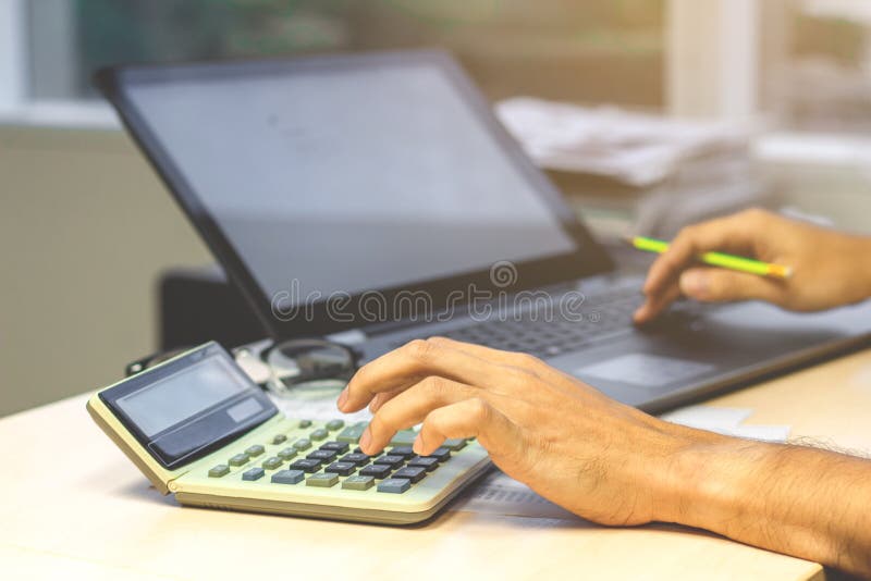 Feche acima das mãos do contador do homem de negócios que trabalham na calculadora imagens de stock royalty free