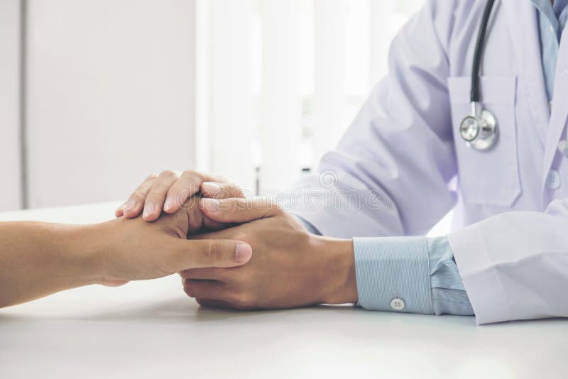 Close up of doctor touching patient hand for encouragement and empathy on the hospital, cheering and support patient, Bad news, medical examination, trust and ethics. Close up of doctor touching patient hand for encouragement and empathy on the hospital, cheering and support patient, Bad news, medical examination, trust and ethics