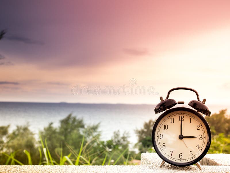 Feche acima de um despertador com fundo da natureza, conceito do tempo imagens de stock royalty free Feche acima de um despertador com fundo da natureza, conceito do tempo imagens de stock royalty free