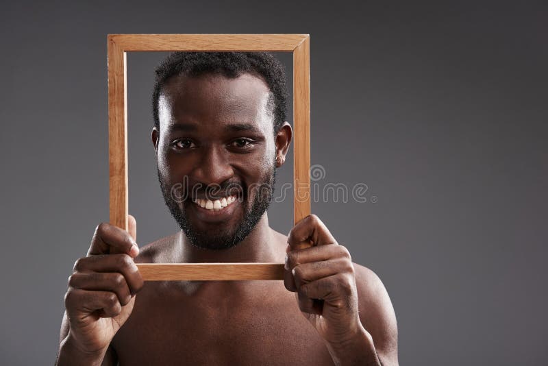 Feche acima de um homem considerável alegre que guarda um quadro da foto imagem de stock royalty free Feche acima de um homem considerável alegre que guarda um quadro da foto imagem de stock royalty free