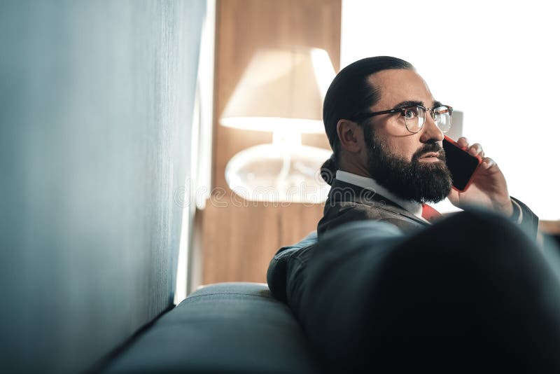 Feche acima do homem de negócios farpado que chama seu secretário que dá instruções imagens de stock royalty free Feche acima do homem de negócios farpado que chama seu secretário que dá instruções imagens de stock royalty free
