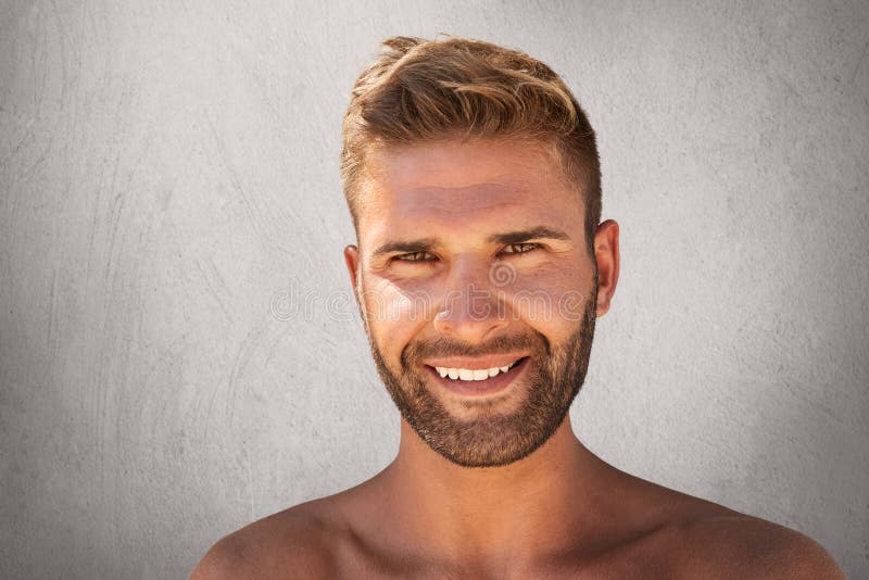 Feche acima do homem novo de sorriso com cerda, penteado na moda, pele saudável pura, tendo a expressão contente Smil macho atrat imagem de stock royalty free Feche acima do homem novo de sorriso com cerda, penteado na moda, pele saudável pura, tendo a expressão contente Smil macho atrat imagem de stock royalty free