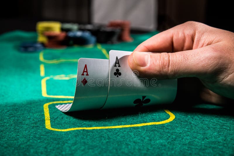 Feche acima do jogador de pôquer com os dois cartões e microplaquetas de jogo dos áss na tabela verde do casino imagens de stock royalty free Feche acima do jogador de pôquer com os dois cartões e microplaquetas de jogo dos áss na tabela verde do casino imagens de stock royalty free