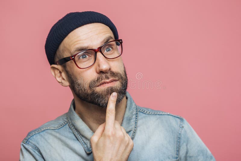 Feche acima do tiro do homem farpado pensativo com os olhos azuis que são profundos nos pensamentos, olhares pensativamente na di imagens de stock Feche acima do tiro do homem farpado pensativo com os olhos azuis que são profundos nos pensamentos, olhares pensativamente na di imagens de stock