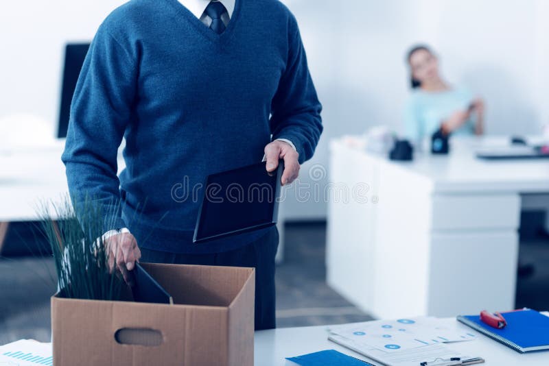 Feche acima dos materiais de escritório maduros da embalagem do homem na caixa foto de stock Feche acima dos materiais de escritório maduros da embalagem do homem na caixa foto de stock