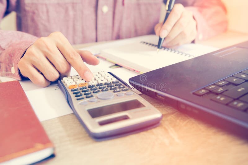 Feche acima dos povos com a calculadora que conta a fatura e que trabalha em h imagem de stock