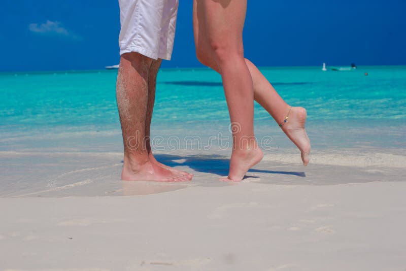 Feche acima dos pés masculinos e fêmeas na areia branca imagem de stock Feche acima dos pés masculinos e fêmeas na areia branca imagem de stock