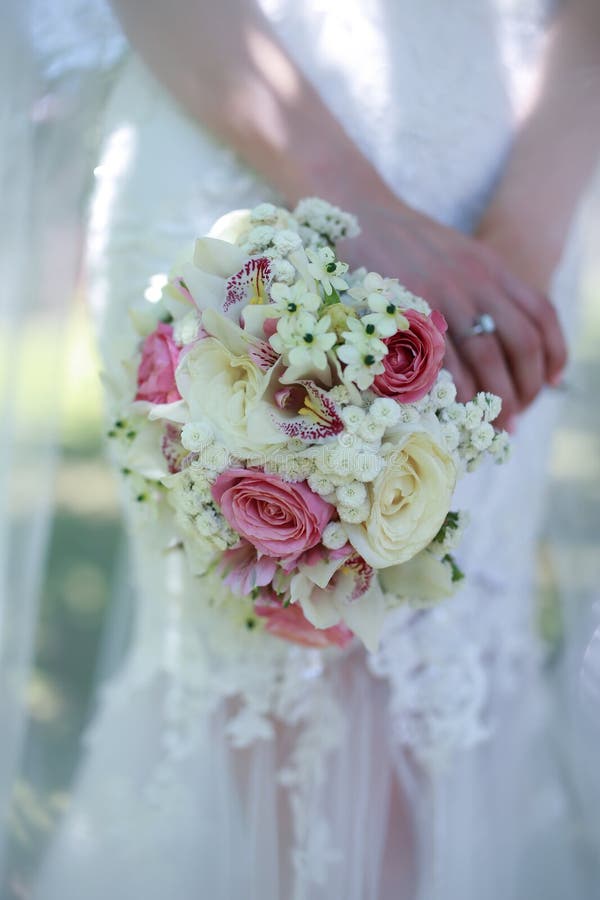 Feche As Mãos Das Noivas Segurando Um Buquê De Flores. Bouquet Noiva Segura  O Buquê Do Casamento Foto de Stock - Imagem de flores, luxo: 202319394