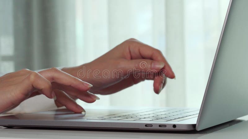 Feche as mãos femininas de uma empresária digitando no teclado do computador portátil
