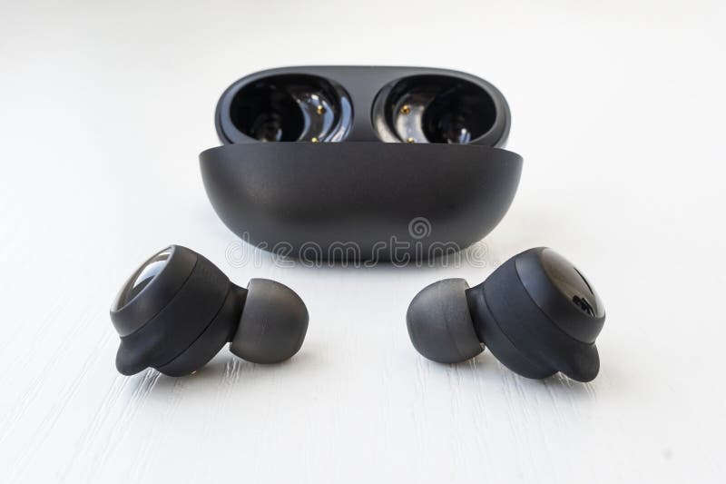 Feche Fones De Ouvido Pretos Sem Fio No Fone De Ouvido Branco foto de stock