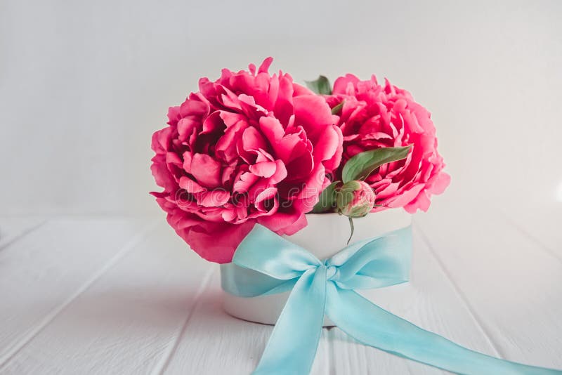 Feche o belo buquê de flores cor-de-rosa numa caixa redonda com fita de sattin turquesa sobre fundo branco de madeira Presente, fotografia de stock royalty free Feche o belo buquê de flores cor-de-rosa numa caixa redonda com fita de sattin turquesa sobre fundo branco de madeira Presente, fotografia de stock royalty free