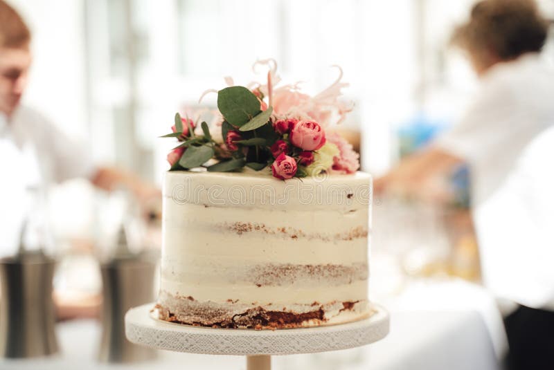 Feminino mão decorando o bolo de aniversário de casamento flor