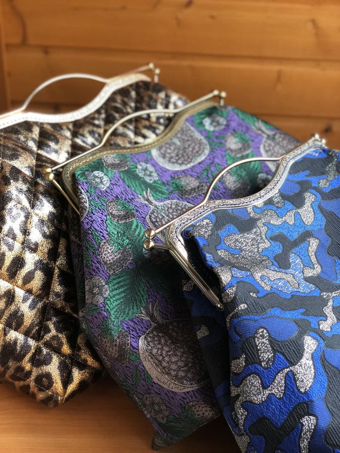 Three womens bags on the table. Travel bag. Fabric bag. Clasp bag. Big habdbag. Small clatch. Three womens bags on the table. Travel bag. Fabric bag. Clasp bag. Big habdbag. Small clatch.