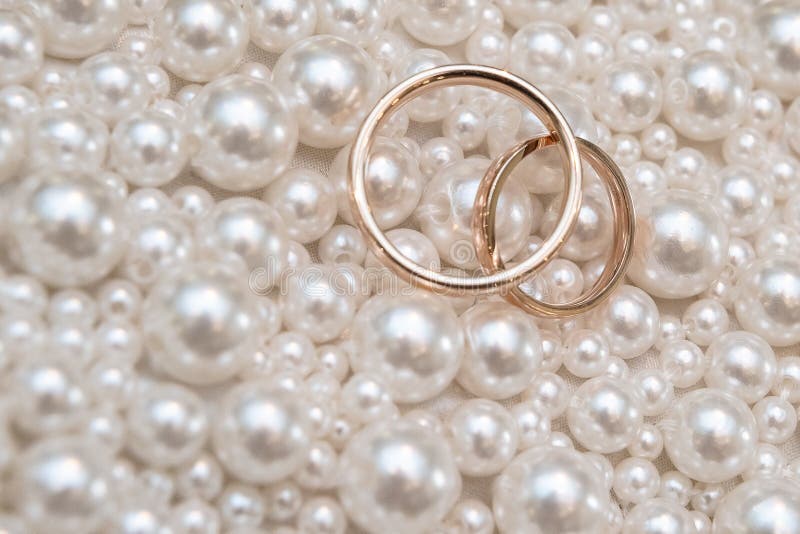 Fedi nuziali con il fondo della collana della perla per nozze o il concetto di giorni di biglietti di S. Valentino : Stile d'anna fotografia stock libera da diritti Fedi nuziali con il fondo della collana della perla per nozze o il concetto di giorni di biglietti di S. Valentino : Stile d'anna fotografia stock libera da diritti