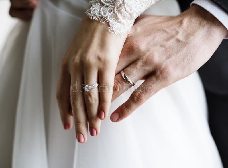 Fedi nuziali di Showing Their Engagement dello sposo e della sposa sulle mani