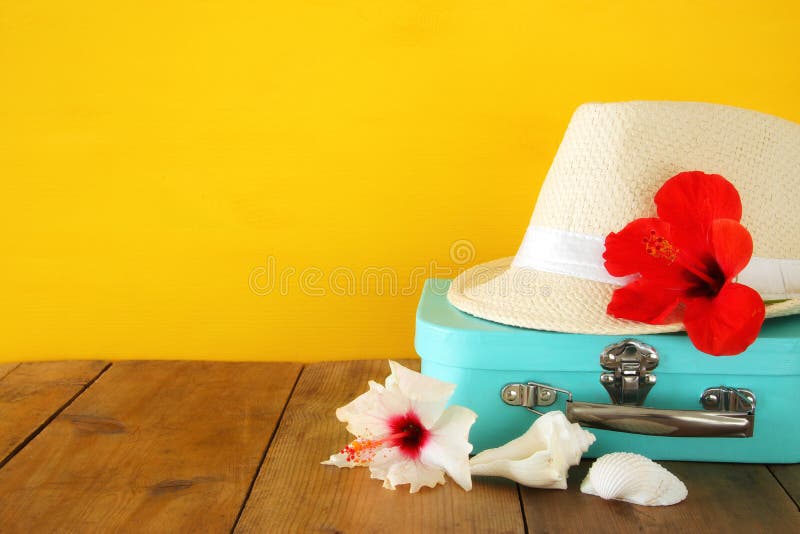 Fedora hat, tropical hibiscus flower on wooden table. relaxation or vacation concept stock photo Fedora hat, tropical hibiscus flower on wooden table. relaxation or vacation concept stock photo