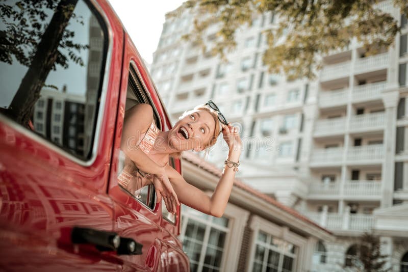 Cheerful woman leaning out of the car window. royalty free stock photos Cheerful woman leaning out of the car window. royalty free stock photos