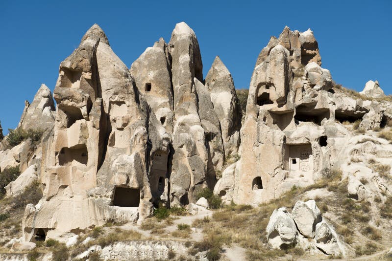 In ancient times people carved out homes in the fairy chimney rock formations in Cappadocia, Turkey. The houses are a popular tourist attraction for people on vacation or holiday. In ancient times people carved out homes in the fairy chimney rock formations in Cappadocia, Turkey. The houses are a popular tourist attraction for people on vacation or holiday.