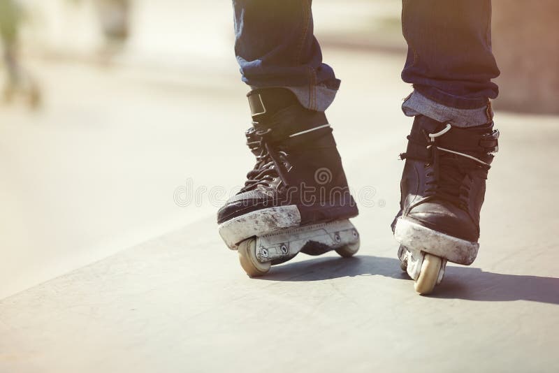 Feet of aggressive inline rollerblader on outdoor skatepark