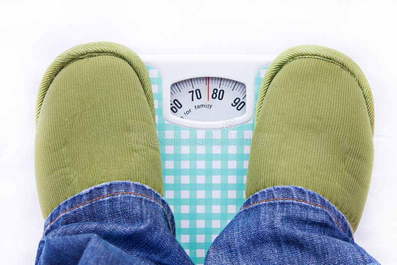 Feet on a bathroom scale showing weight