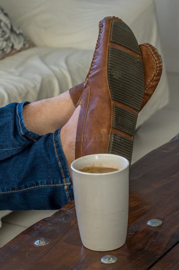 Feet on a coffee table stock image. Image of lounge 157166987