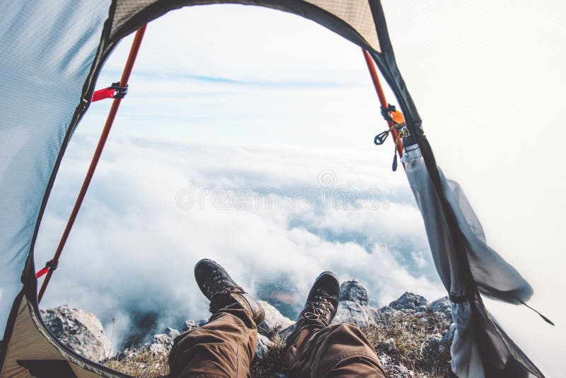 Feet Man relaxing enjoying clouds mountains. Aerial view from tent camping entrance outdoor Travel Lifestyle concept adventure vacations outdoor stock photos Feet Man relaxing enjoying clouds mountains. Aerial view from tent camping entrance outdoor Travel Lifestyle concept adventure vacations outdoor stock photos