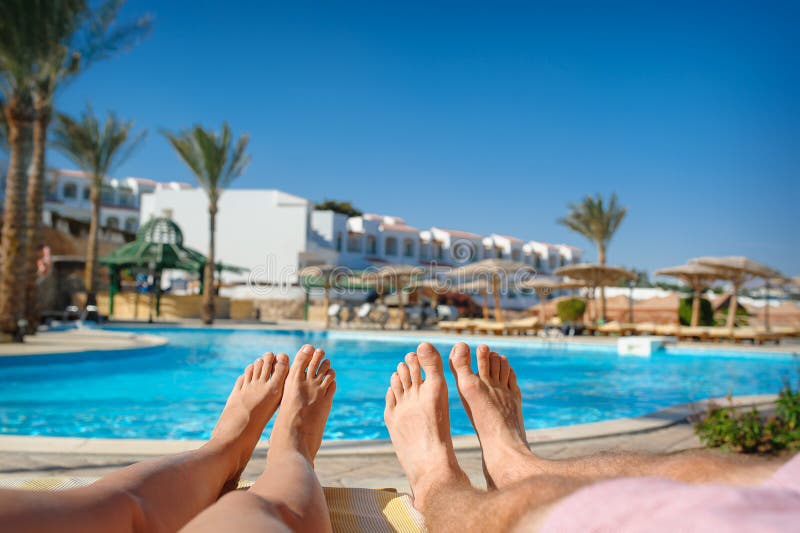 Feet resting on a background of the sea on the beach