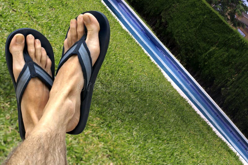 Feet wearing flip flops/ beach sandals relaxing by the swimming pool. Feet wearing flip flops/ beach sandals relaxing by the swimming pool