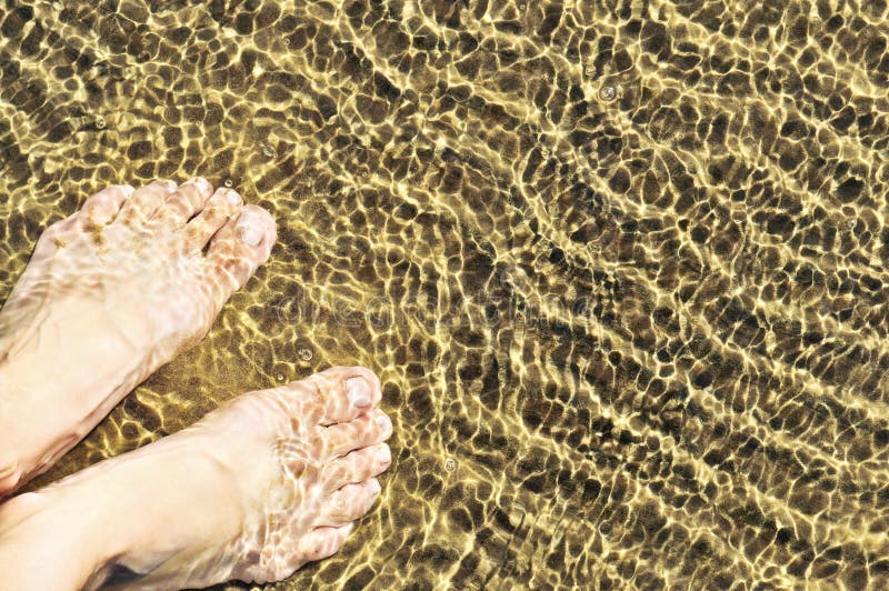 Feet in shallow water royalty free stock photo