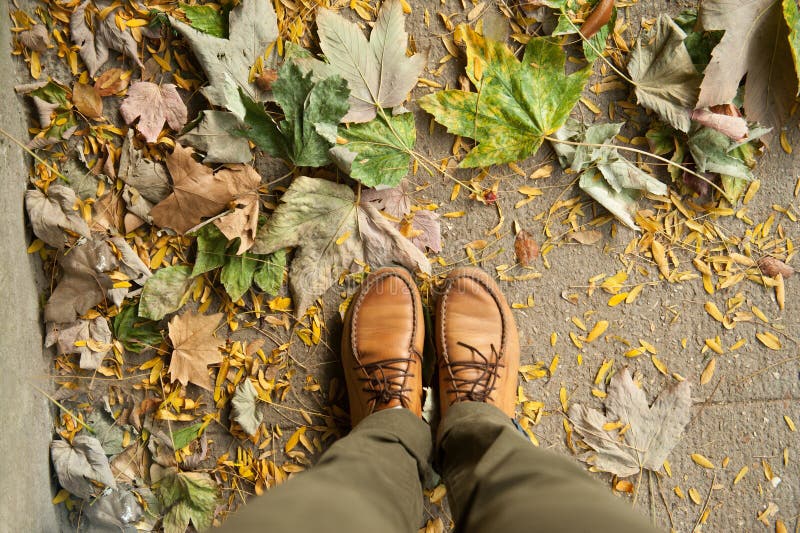 Feet in shoes on the autumn sidewalk