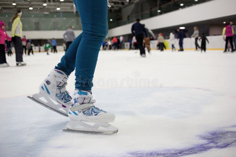Feet skater in motion on the ice rink with many