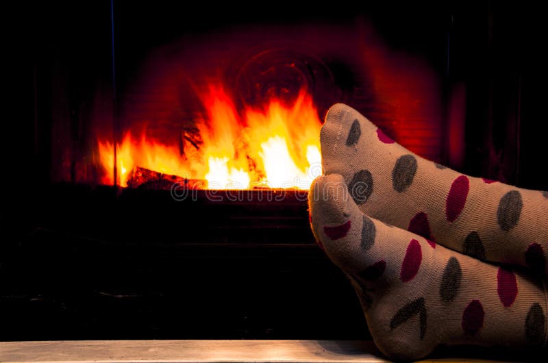 Feet in socks of all the family warming by cozy fire royalty free stock photos